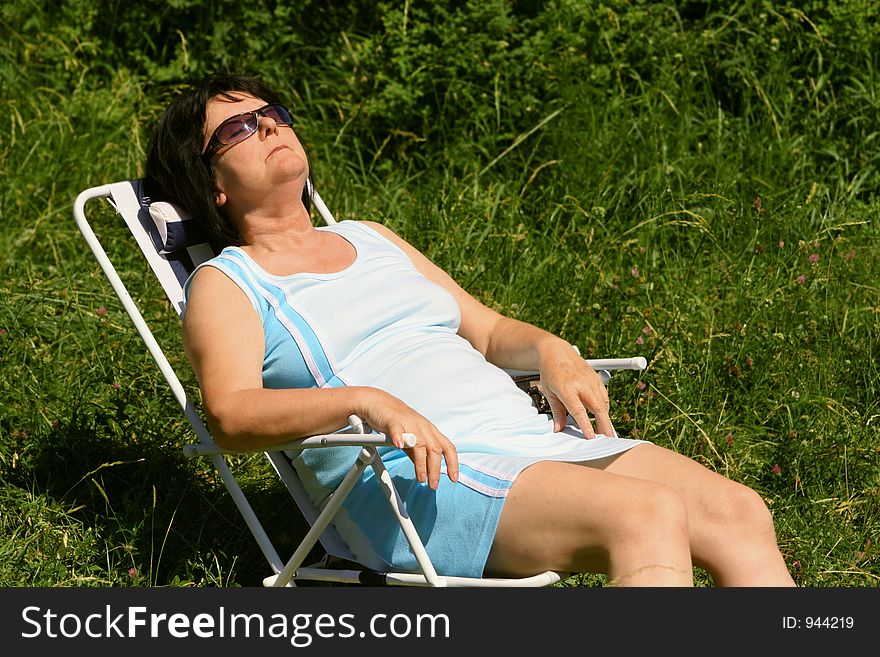 A woman sitting in the sun. A woman sitting in the sun.