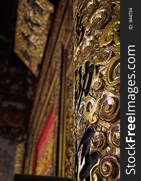 Elaborate gold pillar in a Chinese Temple with Chinese writing in background. Elaborate gold pillar in a Chinese Temple with Chinese writing in background