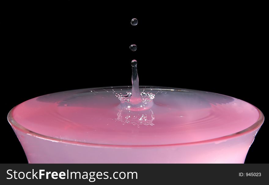 Pink water drops in a glass