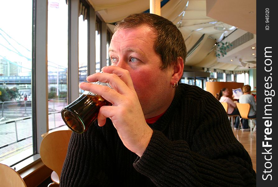 Man drinking cola in cafe