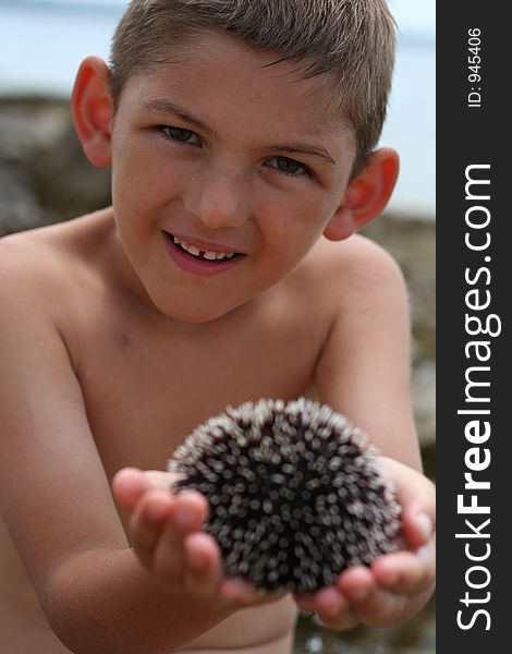 Kid showing sea urchin. Kid showing sea urchin.