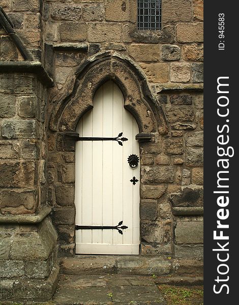 White door at the side of a church with beautiful stone surround