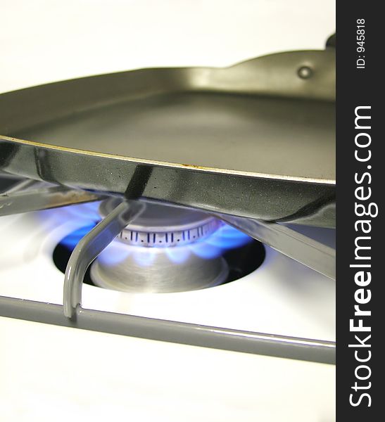 View of an empty frying pan on lit burner. View of an empty frying pan on lit burner