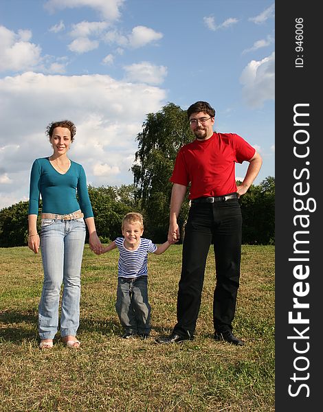 Family with son stand on meadow