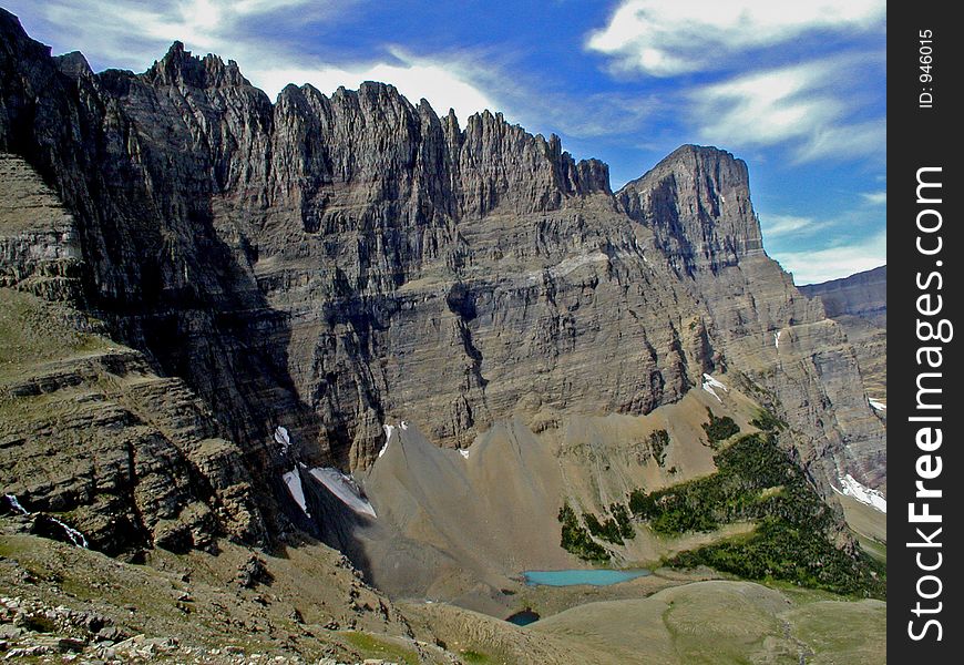This picture was taken from Piegan Pass and shows the backside of the Garden Wall and a small snow melt pond in Glacier National Park. This picture was taken from Piegan Pass and shows the backside of the Garden Wall and a small snow melt pond in Glacier National Park.