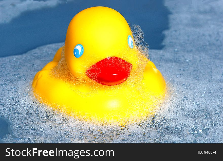 Bright yellow rubber duck swiming on a sea of bubbles. Bright yellow rubber duck swiming on a sea of bubbles