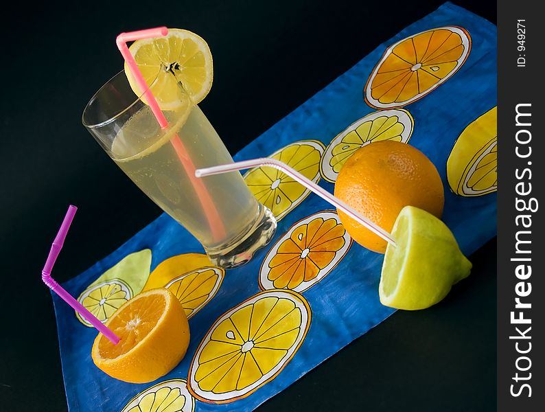 Fresh fruits, lemon juice at napkien with citrus motives. Fresh fruits, lemon juice at napkien with citrus motives
