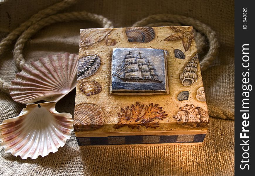 Painted box laying at jute, two sea shells beside. Painted box laying at jute, two sea shells beside