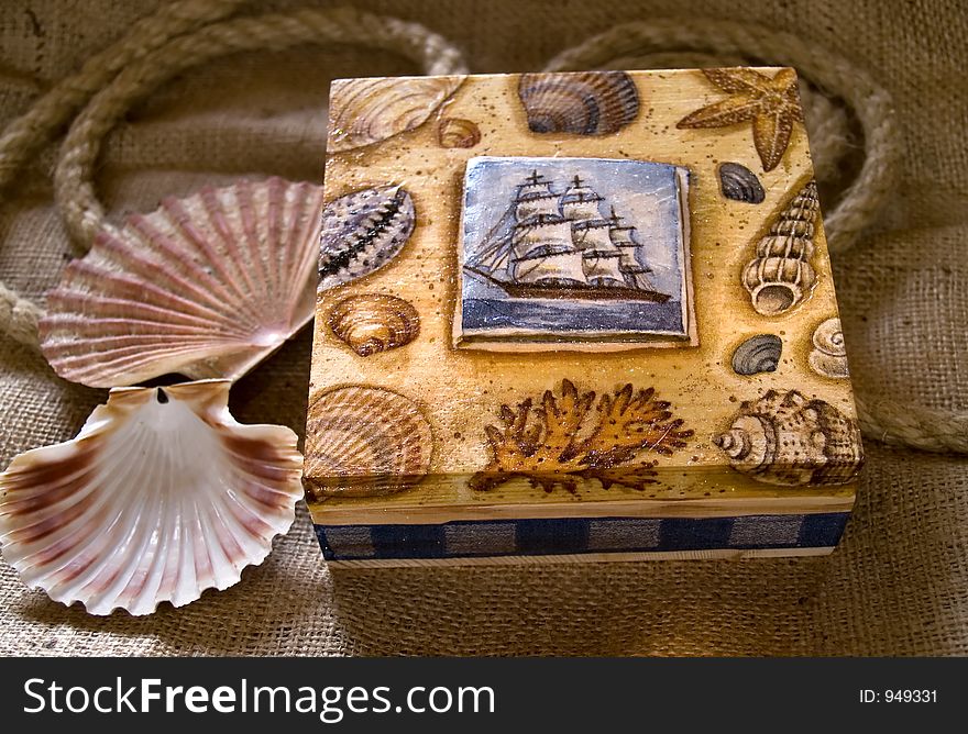 Painted box laying at jute, two sea shells beside. Painted box laying at jute, two sea shells beside