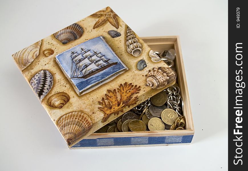 Painted box filled with coins, white background. Painted box filled with coins, white background