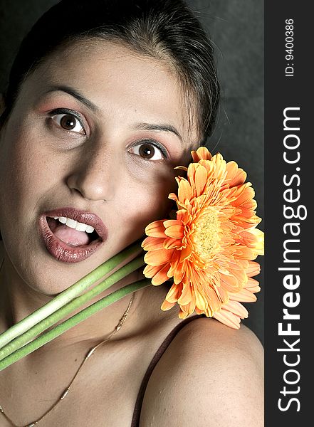 Girl with flower looking beautiful in studio.