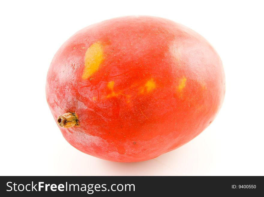 Single red and orange ripened mango fruit with a short stalk on a white background. Single red and orange ripened mango fruit with a short stalk on a white background