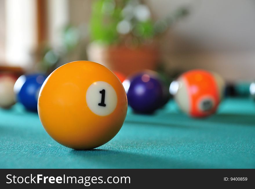 Billiard ball on a billiard table, several balls in blurry background. Billiard ball on a billiard table, several balls in blurry background