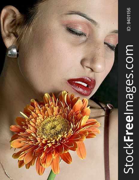 Girl with flower looking beautiful in studio.