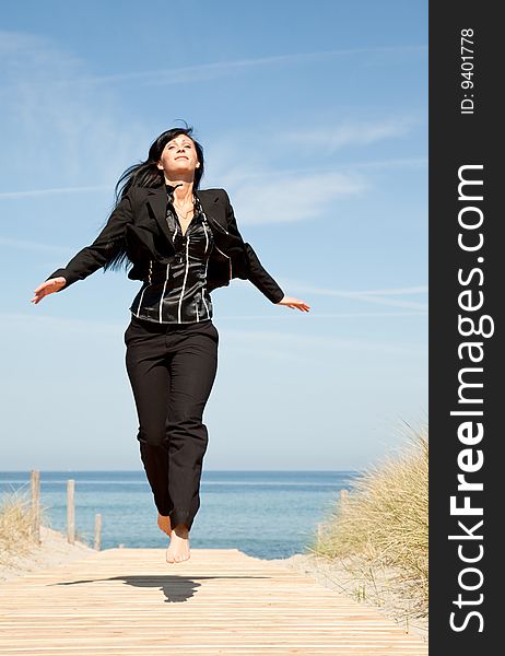 Successful formal woman jumping running on the beach. Successful formal woman jumping running on the beach