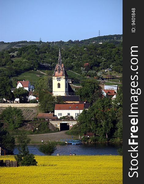 Czech rural landscape including several layups - field, river Elbe, church in village Prackovice and hill in the background.