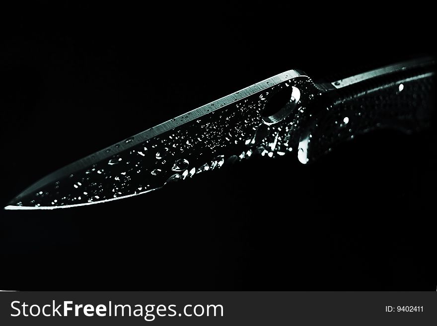 Sharp knife covered with water drops