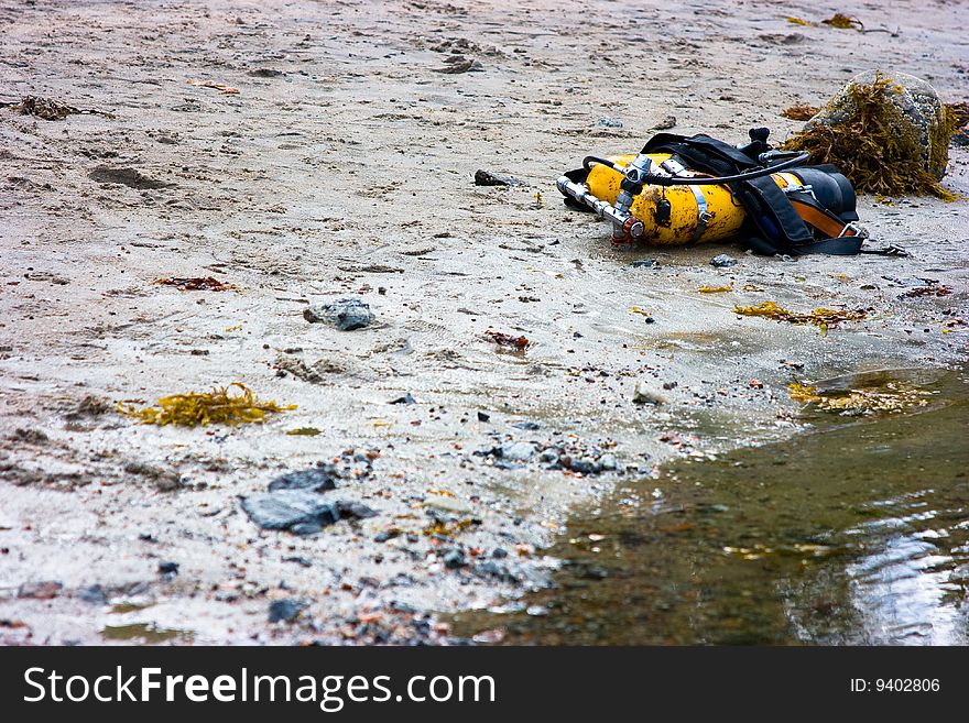Yellow cylinders lying on sandy coast for diving