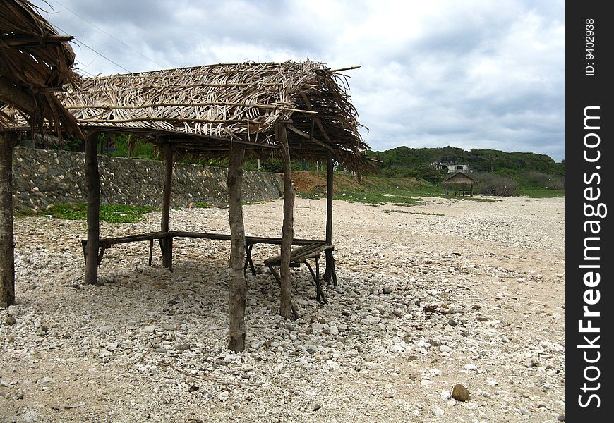 Old cottage made of indigenous materials on rocky shore