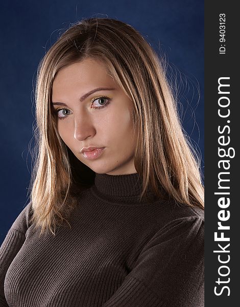 Portrait of the beautiful young girl, it is photographed on a dark blue background. Portrait of the beautiful young girl, it is photographed on a dark blue background