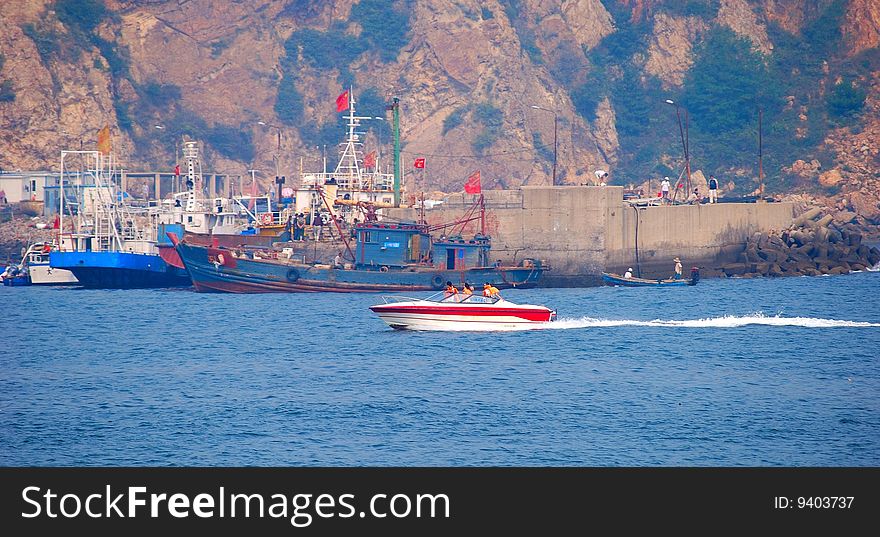 Port. Group of ships. Motorboat with rescues.