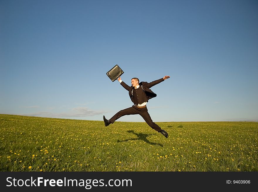 Jumping Businessman in meadow - green grass and blue sky. Jumping Businessman in meadow - green grass and blue sky