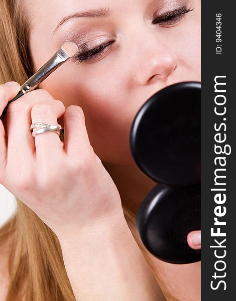 Nice caucasian model applying makeup with brush. Nice caucasian model applying makeup with brush