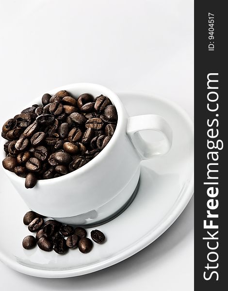 Coffee beans in a white cup isolated on white background. Coffee beans in a white cup isolated on white background.