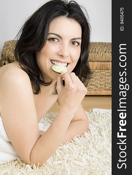 Young, beauty woman relaxing and eating cucumber