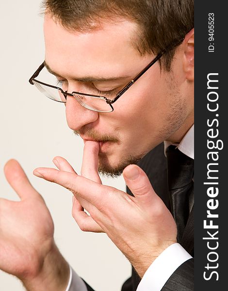 Young handsome businessman licking fingers. Young handsome businessman licking fingers
