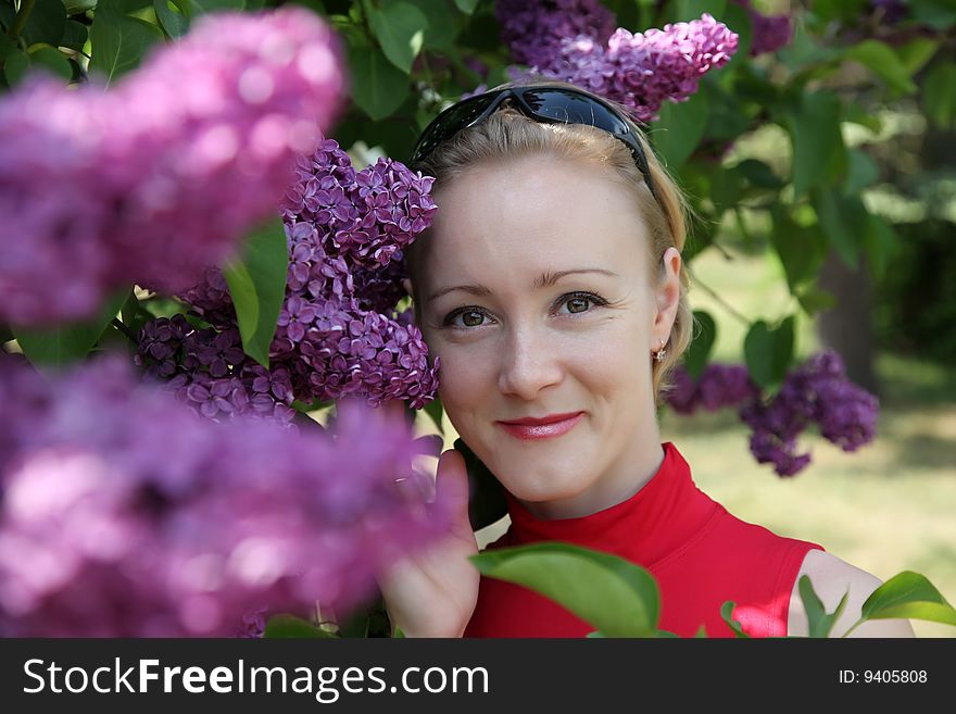 Young woman with flowers of lilac
