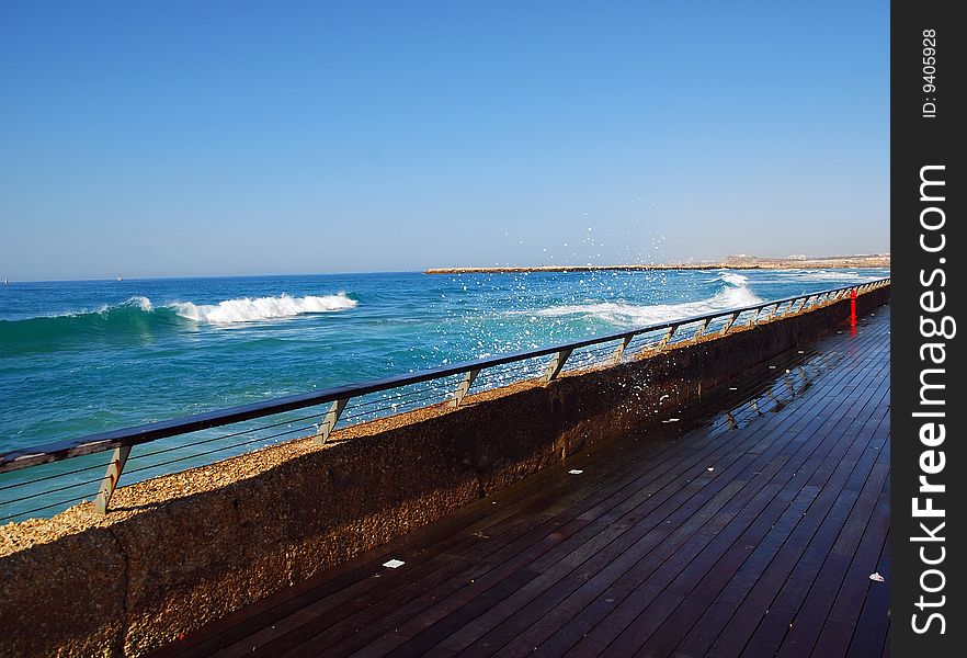The marine of Tel-Aviv, waves breaking on the wooden pier. The marine of Tel-Aviv, waves breaking on the wooden pier.