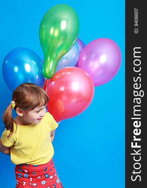 Little girl holding colorful balloons on a blue background. Little girl holding colorful balloons on a blue background