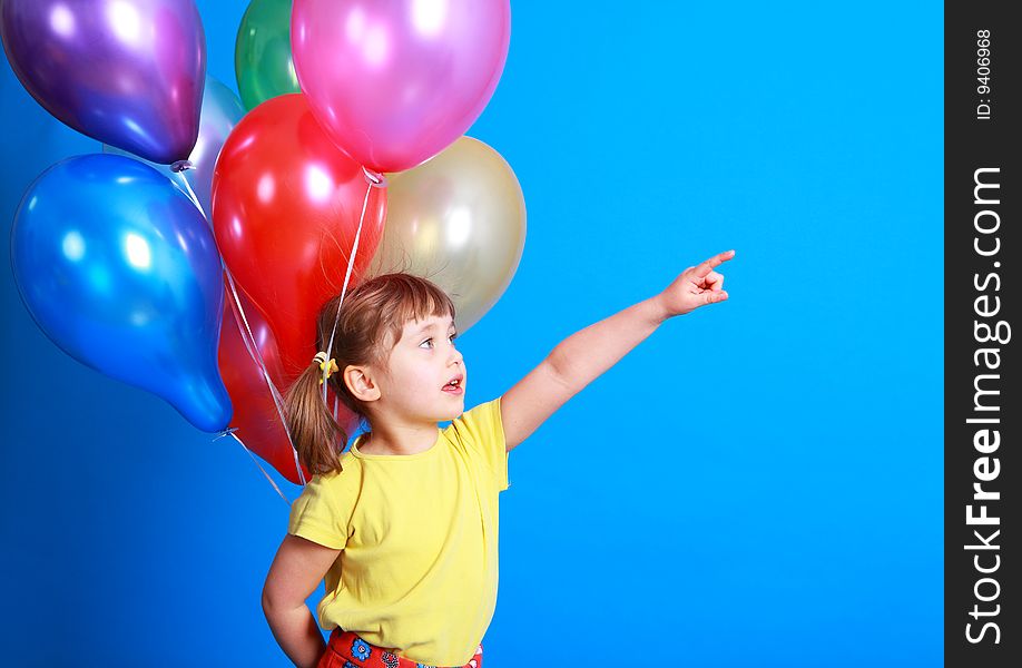 Little girl holding colorful balloons on a blue background