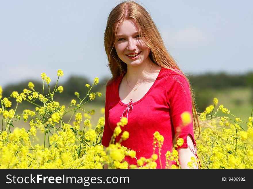 Outdoor portrait of beautiful girl with long hair in yellow flowers
