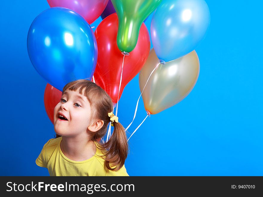 Little girl holding colorful balloons