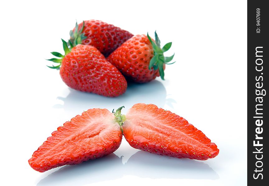The whole strawberry and half isolated on white