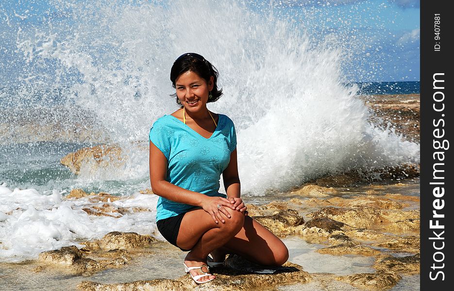 The girls' portrait with wave splashes in a background on Grand Cayman island, Cayman Islands. The girls' portrait with wave splashes in a background on Grand Cayman island, Cayman Islands.