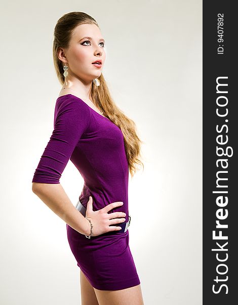 Beautiful girl in purple dress studio shot