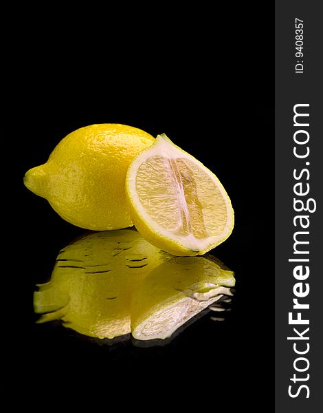 Lemon on mirror over black background