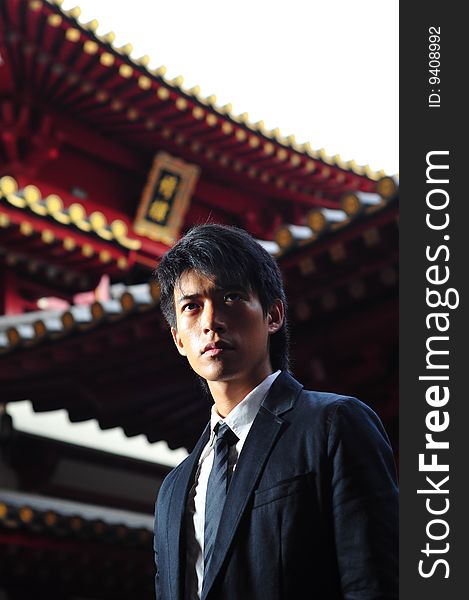 Smart Asian man in business suit in chinese temple. Smart Asian man in business suit in chinese temple