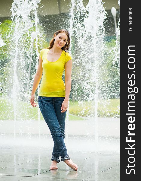 Young caucasian girl playing at fountain