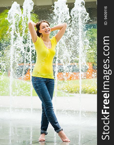 Young caucasian girl playing at fountain