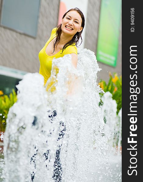 A young caucasian girl playing at fountain