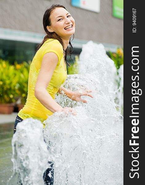 Young caucasian girl playing at fountain