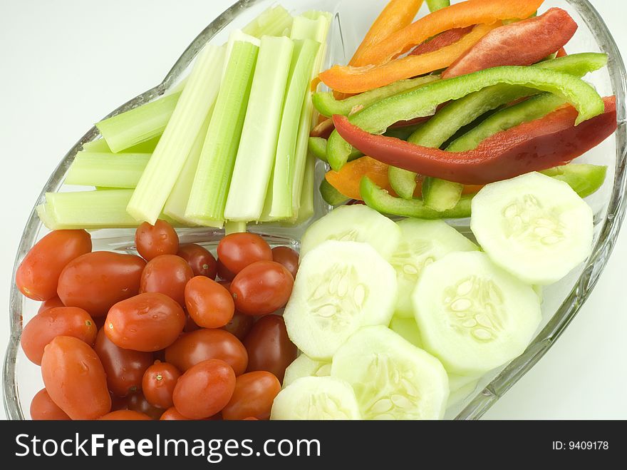 A glass plate full of colorful cut vegetables diagonal view with copy space. A glass plate full of colorful cut vegetables diagonal view with copy space