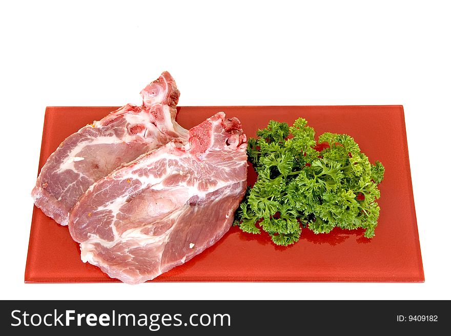 Pork chops on red plate, white background, studio shot