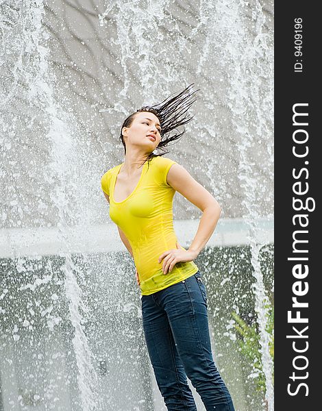 Young caucasian girl playing at fountain