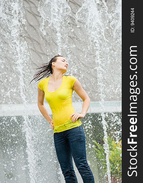 A young caucasian girl playing at fountain