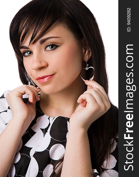 Beautiful brunette in black and white clothes holding heart-shaped earrings